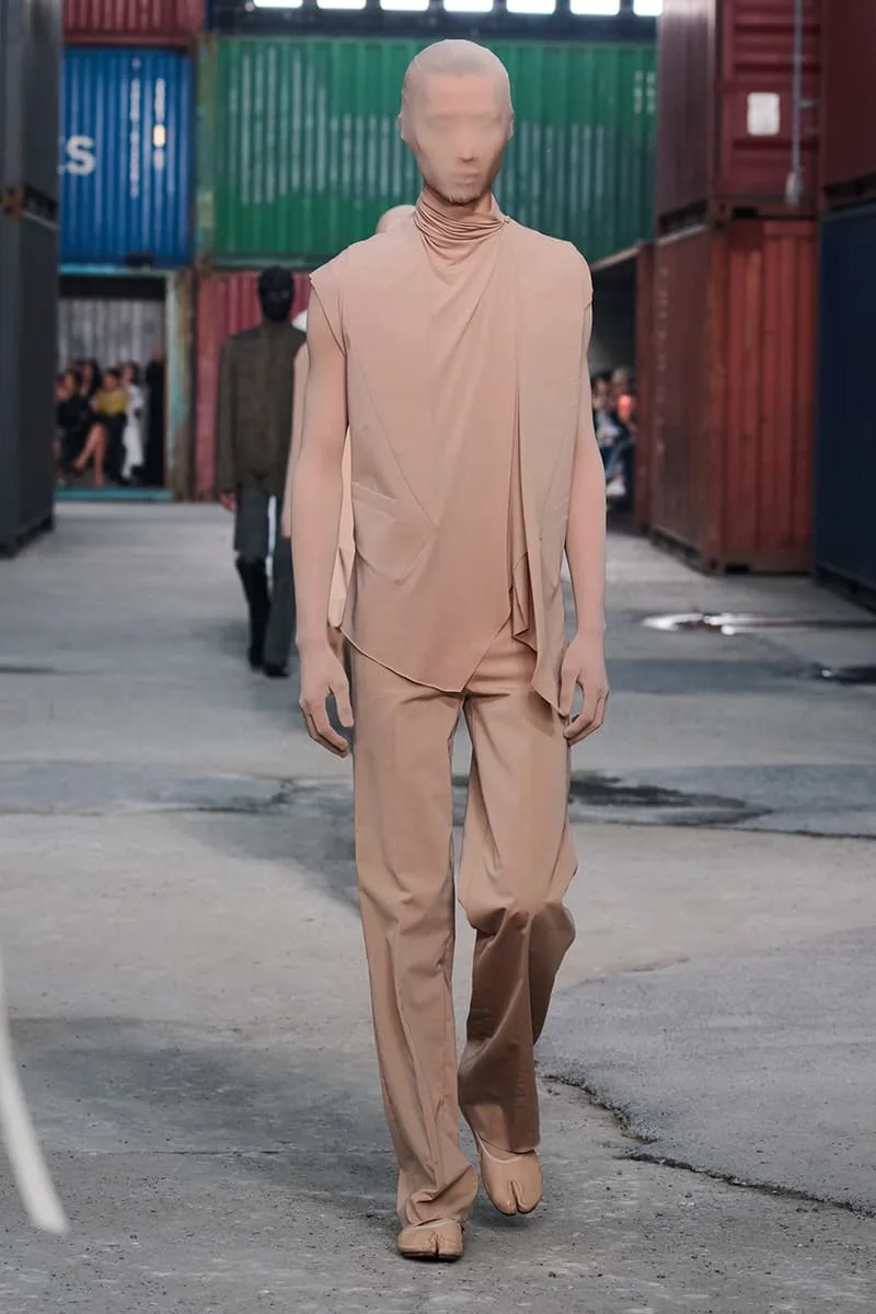 Collection Maison Margiela FW26 à la Shanghai Fashion Week par Glenn Martens : Maison Margiela FW26 apporte un marché aux puces parisien dans un chantier naval de Shanghai, prêt-à-porter artisanal