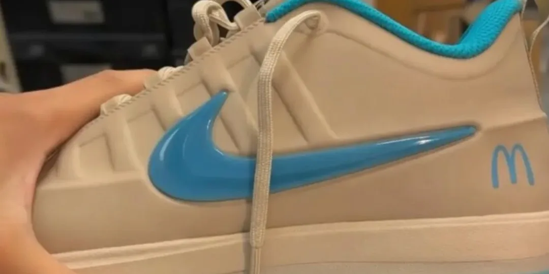 Basket beige avec logo bleu et McDonald's, main visible tenant la chaussure