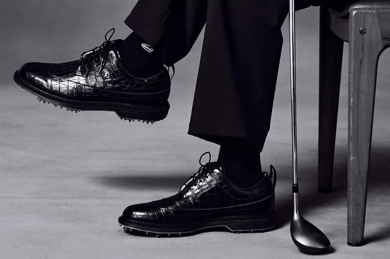 Chaussures de golf élégantes, homme assis avec un club.