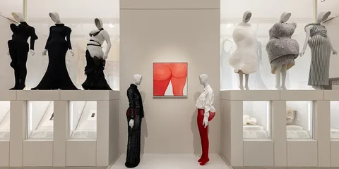 Exposition de mode avec mannequins et œuvre d'art central