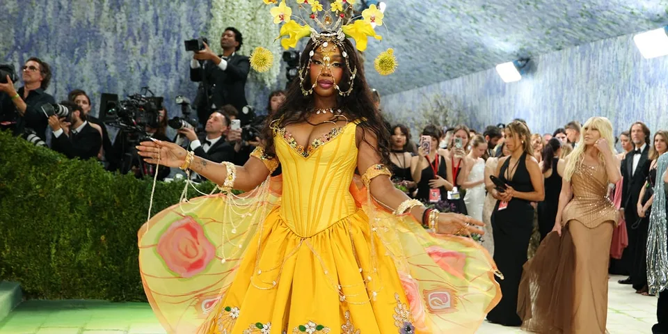 Personne en robe jaune extravagante à un événement prestigieux.