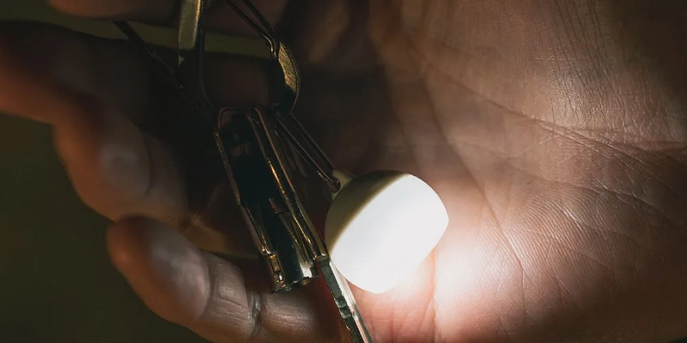 Main avec des clés et une lumière blanche emboutie