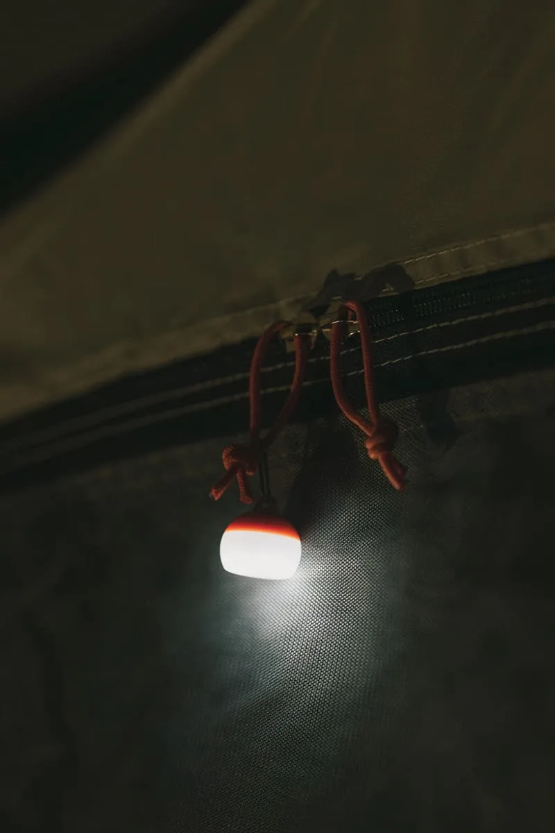 Lampe suspendue émettant une lumière douce sur fond sombre