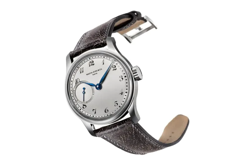 Montre classique avec bracelet marron et cadran blanc.