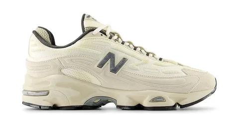 Chaussure de sport New Balance crème avec logo sur le côté.