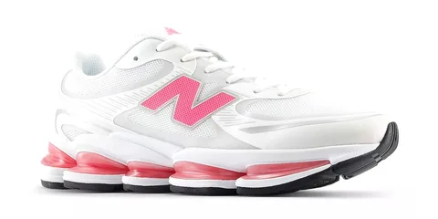 Une chaussure de sport blanche avec des accents roses et semelle épaisse.