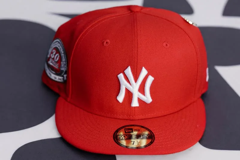 Casquette rouge avec logo 'NY' blanc sur le devant.