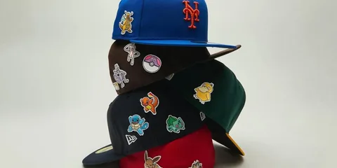 Pile de casquettes colorées avec des patchs Pokémon sur chacun.