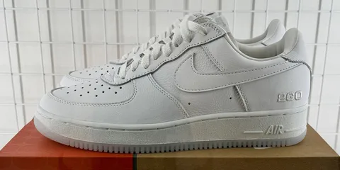 Chaussures blanches Nike avec le numéro 260 sur le côté.