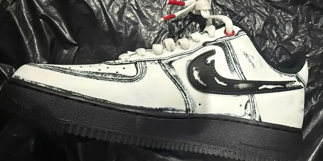 Chaussure blanche et noire avec motif artistique, semelle foncée.
