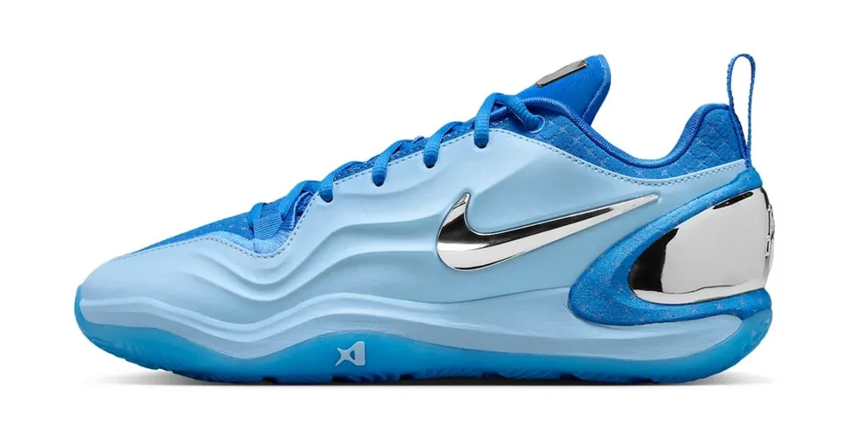 Chaussure de sport bleue avec logo argenté sur le côté et talon chromé.
