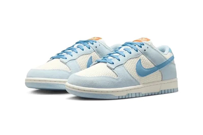 Baskets Nike Dunk basses bleu clair et beige, logo orange.