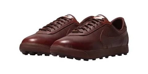 Chaussures marron avec semelle à crampons et logo visible sur le côté.