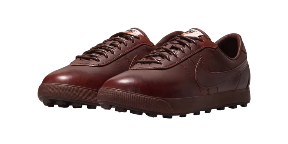 Chaussures marron avec semelle à crampons et logo visible sur le côté.
