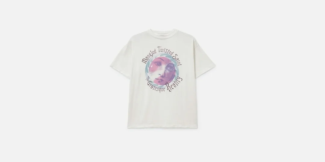 T-shirt blanc avec un visage artistique et texte imprimé.