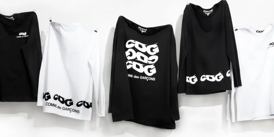 Cinq t-shirts CDG noirs et blancs sur fond blanc.