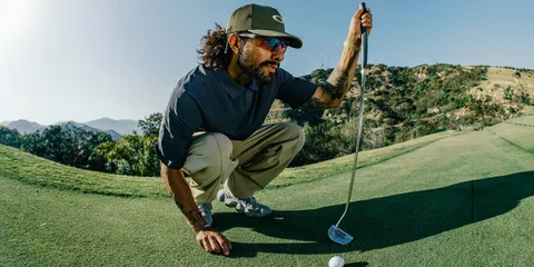 Homme jouant au golf sur un parcours montagneux.