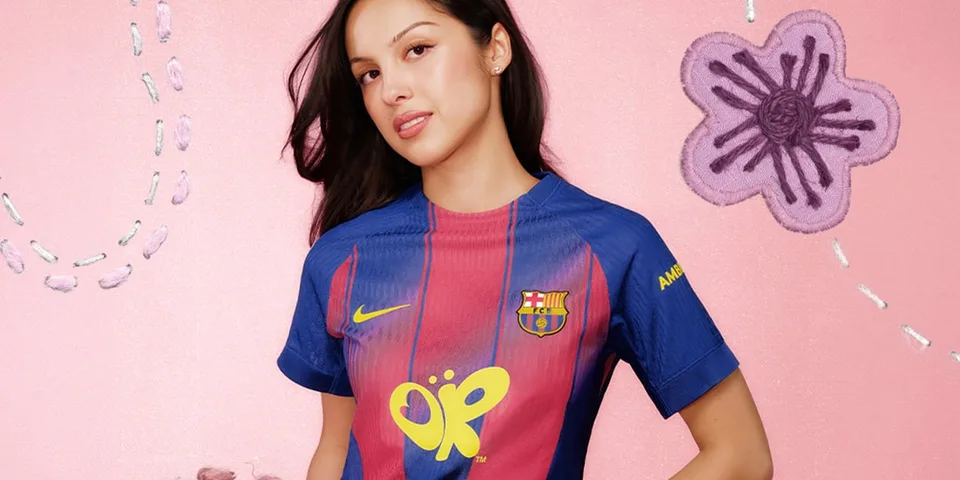 Femme en maillot de football Barça devant un fond rose avec fleurs brodées.