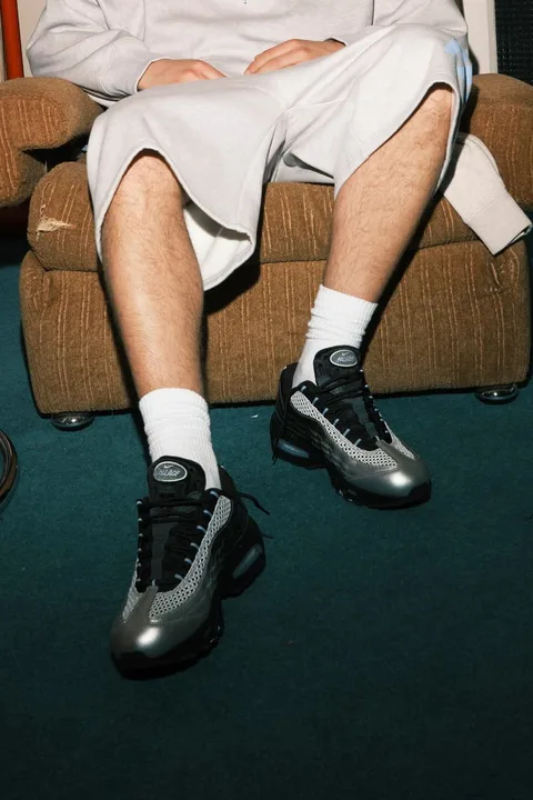 Personne assise, vêtue de chaussures de sport et de chaussettes blanches.
