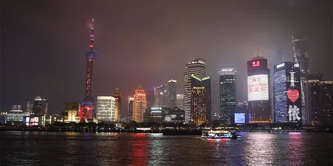 Vue nocturne de la ligne d'horizon de Shanghai avec des gratte-ciels éclairés au bord de l'eau.