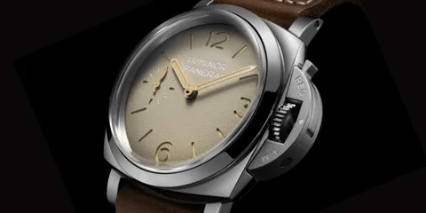Montre avec cadran beige et bracelet en cuir marron.