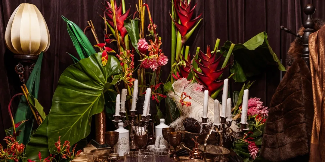 Arrangement floral vibrant avec bougies et objets vintage.