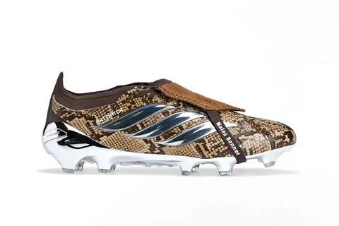 Chaussure de football avec motif camouflage et crampons métalliques.