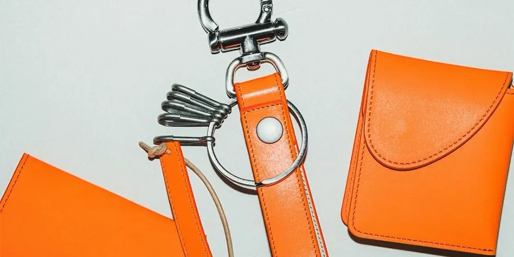 Accessoires en cuir orange sur fond neutre