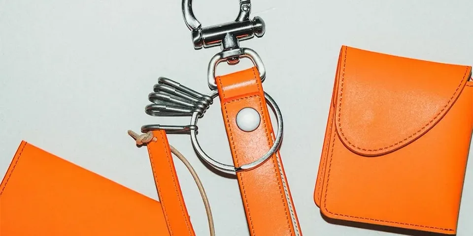 Accessoires en cuir orange sur fond neutre