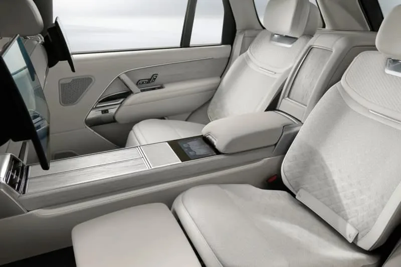 Intérieur luxueux d'une voiture avec sièges en cuir blanc et écran.