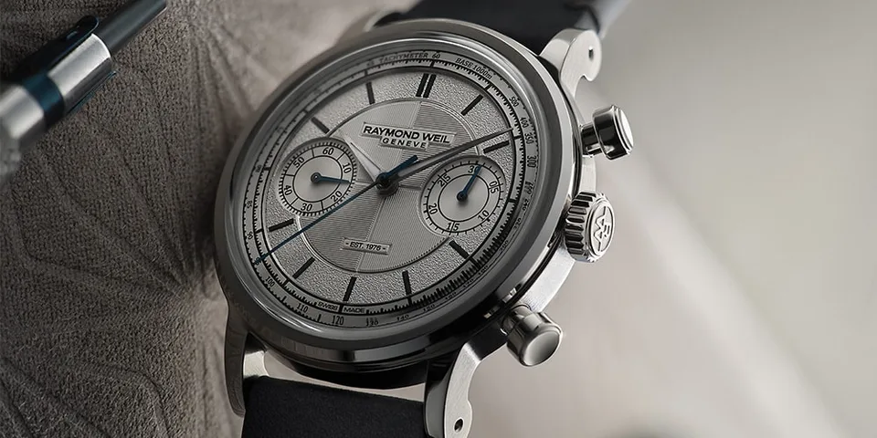 Montre design élégant avec cadran argenté et bracelet noir.