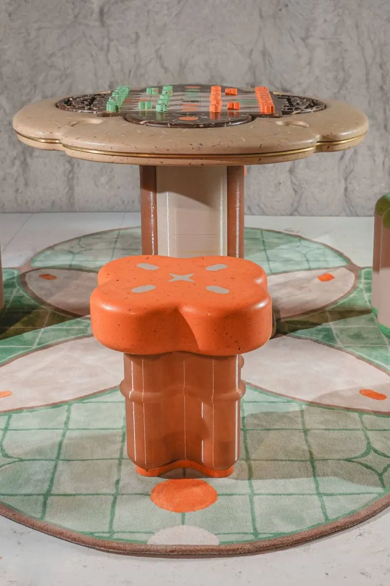Table et tabouret en forme de champignon avec un tapis carreauté.
