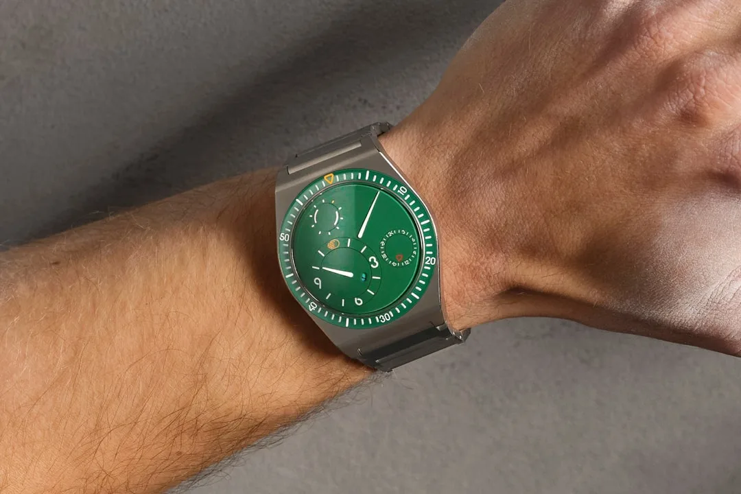 Une montre-bracelet moderne avec un cadran vert et design unique.