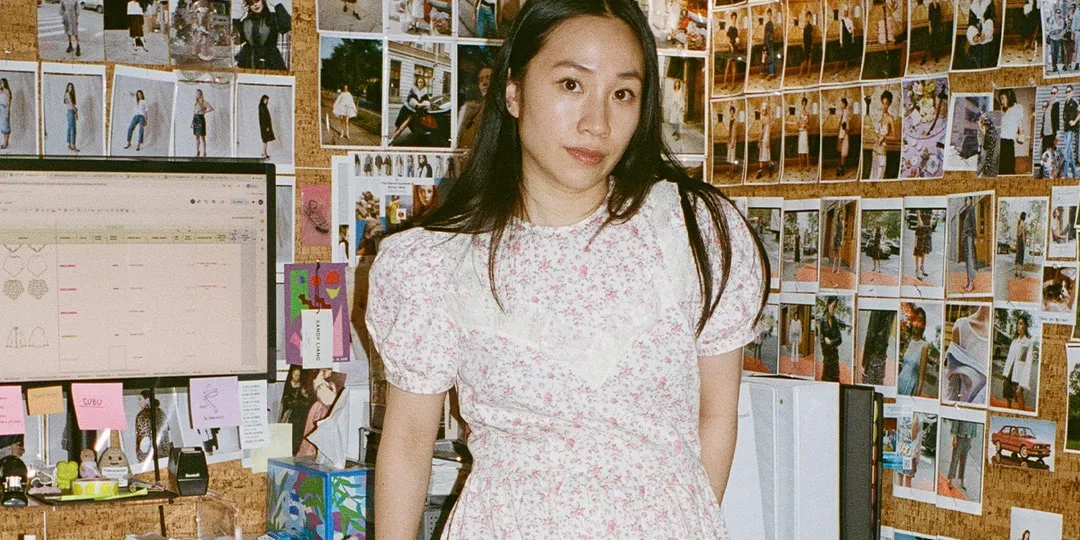 Femme en robe à fleurs, bureau avec photos au mur et écran d'ordinateur