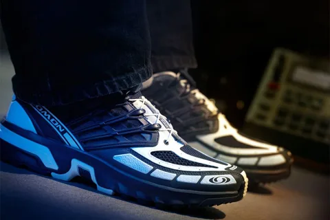 Personne portant des baskets modernes avec des lacets noirs et blancs.