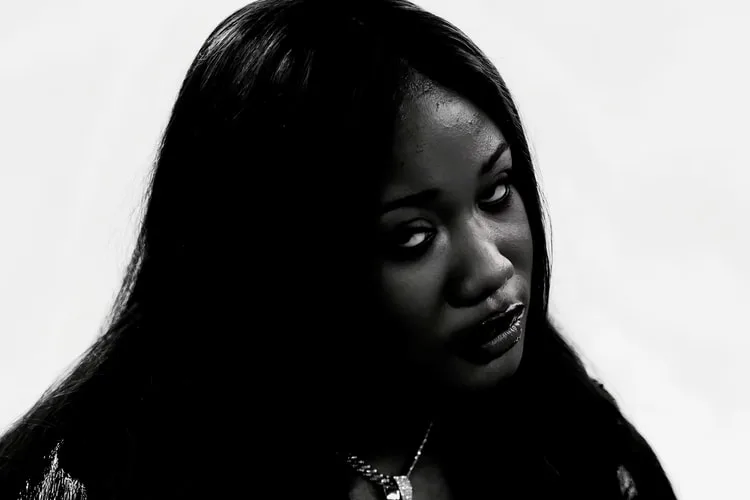 Portrait en noir et blanc d'une femme avec expression sérieuse.