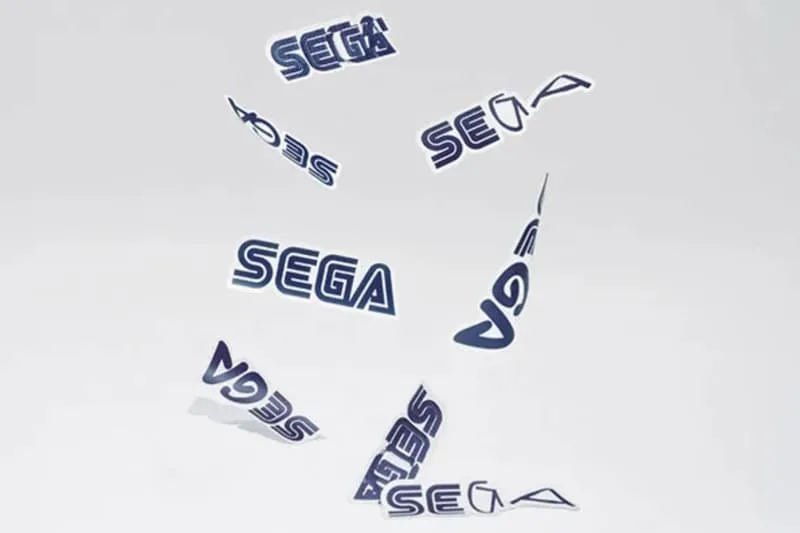 Logos SEGA déformés et suspendus dans les airs sur fond blanc.