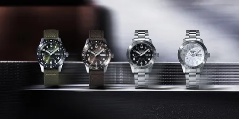 Quatre montres-bracelets avec différents cadrans et bracelets, posées sur une surface.
