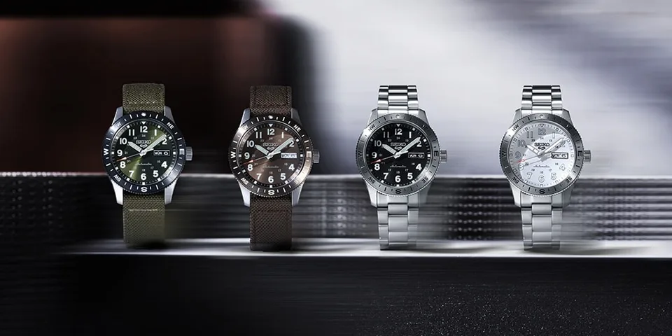Quatre montres-bracelets avec différents cadrans et bracelets, posées sur une surface.