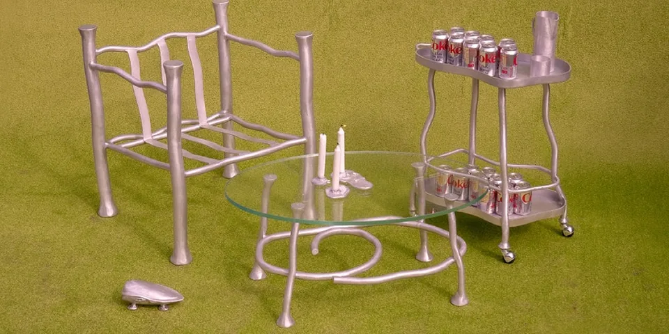 Mobilier en aluminium avec canettes de soda sur un chariot à roulettes, fond vert.