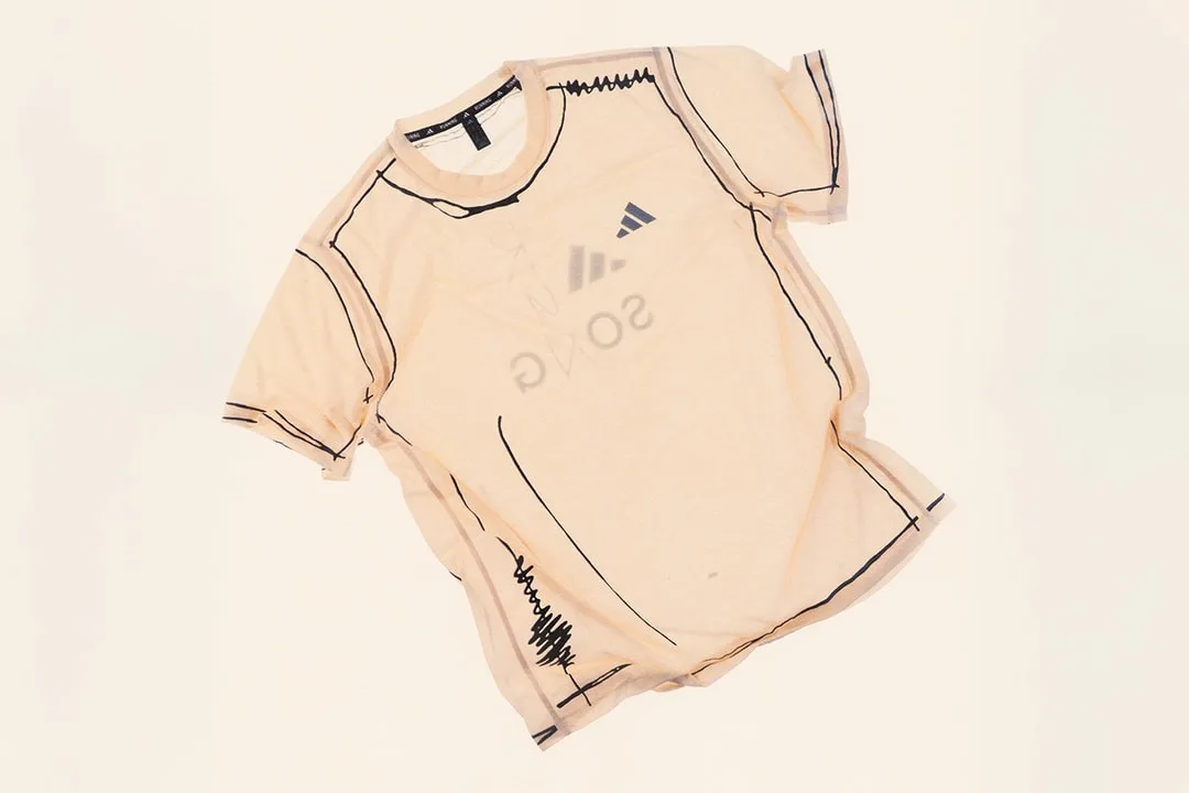 T-shirt beige avec motifs noirs et logo illisible
