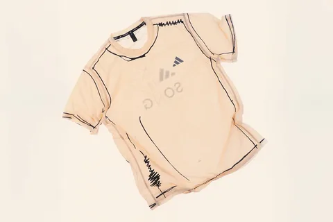 T-shirt beige avec motifs noirs et logo illisible