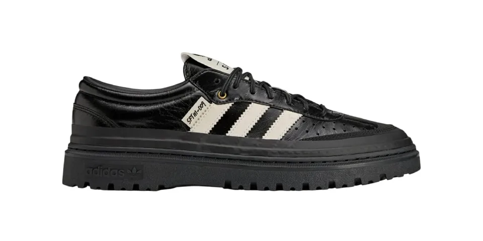 Chaussure noire Adidas avec semelle épaisse et bandes blanches