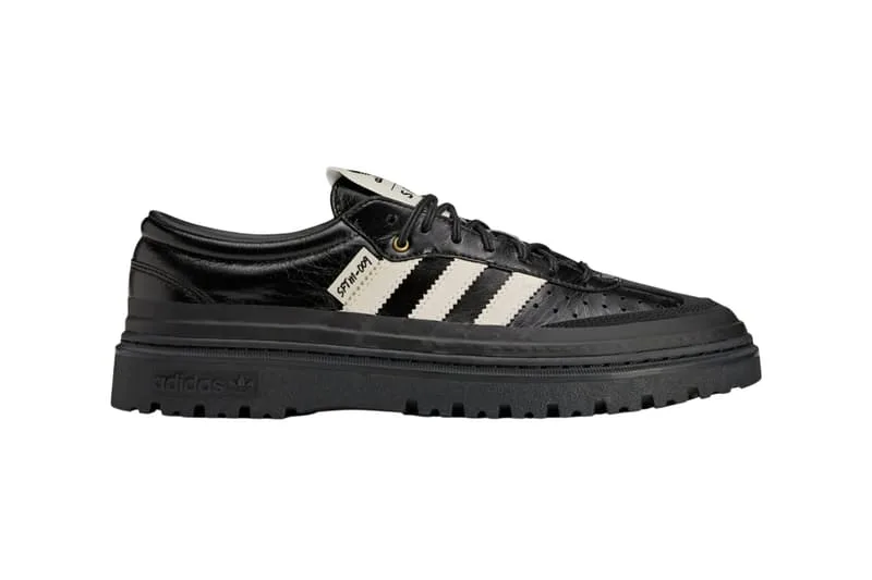 Chaussure noire Adidas avec détails blancs et semelle épaisse.