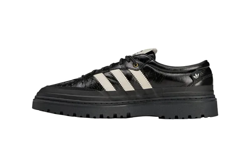 Chaussure noire avec bandes blanches et semelle épaisse.