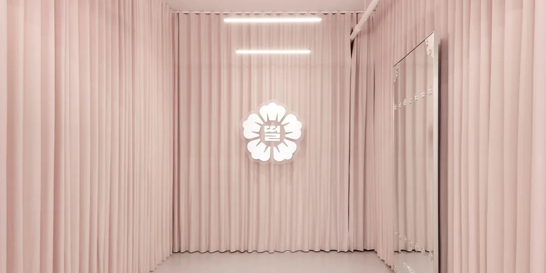 Intérieur rose avec logo de fleur lumineux sur le mur.