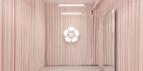 Intérieur rose avec logo de fleur lumineux sur le mur.