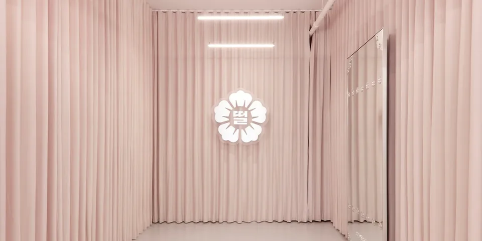 Intérieur rose avec logo de fleur lumineux sur le mur.