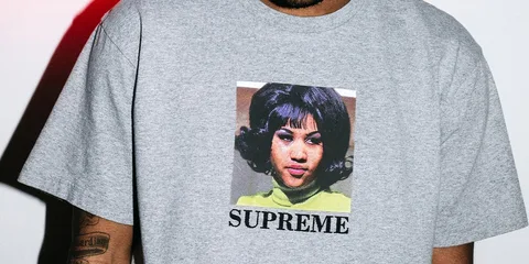 T-shirt gris avec une image et 'SUPREME' imprimé.