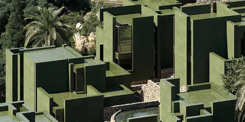 Architecture moderne en blocs verts avec palmiers.